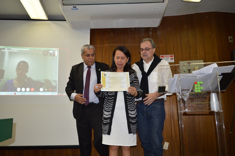 Emocionados, os pais de Laís recebem o título póstumo, entregue pelo reitor do IFG, Jerônimo Rodrigues